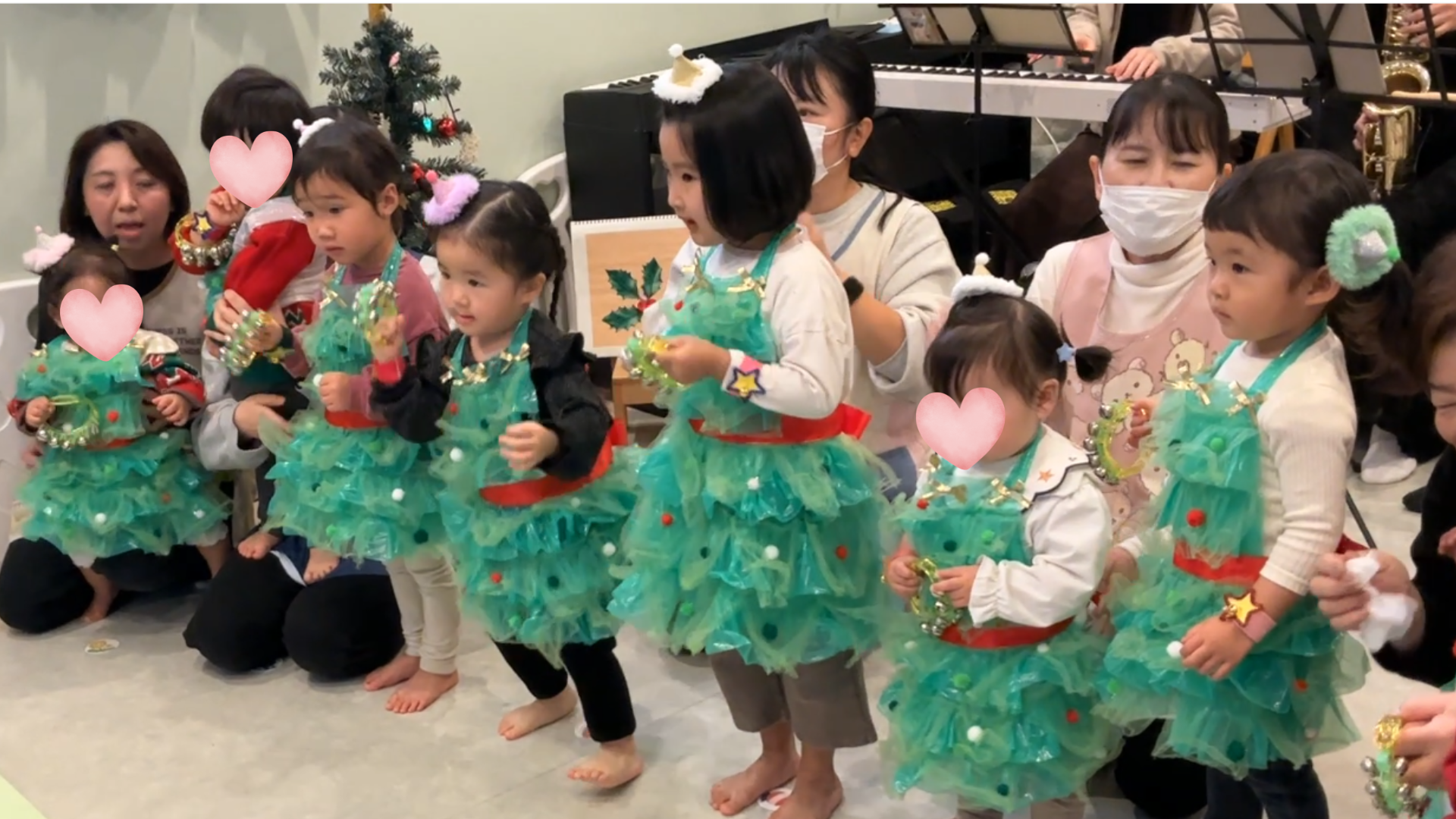 クリスマス会で鈴を振って踊る子供たち